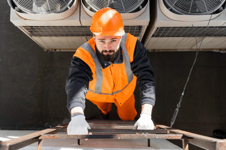 man climbing a ladder in hi vis protective gear looking into camera